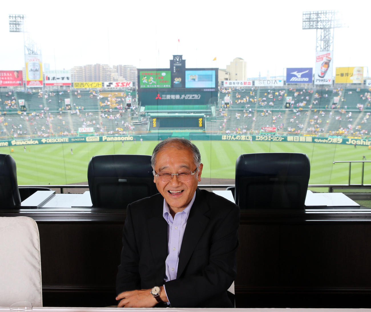 甲子園球場が一望できる貴賓室で笑顔を見せる、当時の阪神坂井オーナー（2014年6月撮影）