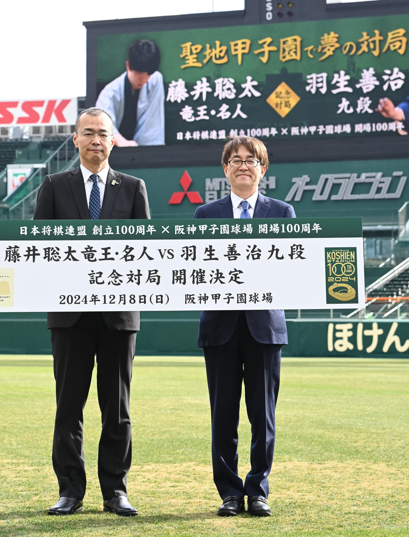 会見を終え甲子園球場で記念撮影をする（左から）阪神甲子園球場長・向井格郎、日本将棋連盟会長・羽生善治（撮影・石井愛子）