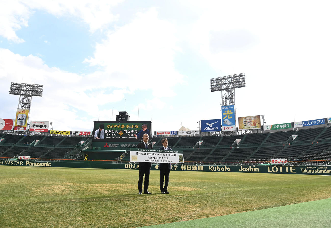 会見を終え甲子園球場で記念撮影をする（左から）阪神甲子園球場長・向井格郎、日本将棋連盟会長・羽生善治（撮影・石井愛子）