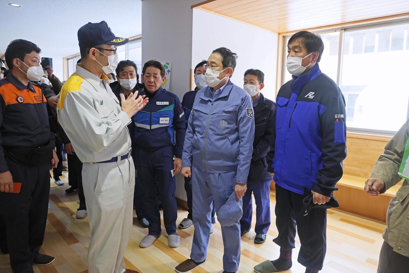 石川県輪島市の避難所を訪れ、坂口茂市長（手前左）から説明を受ける岸田首相（同中央）と馳浩知事（同右）＝14日午前（代表撮影）