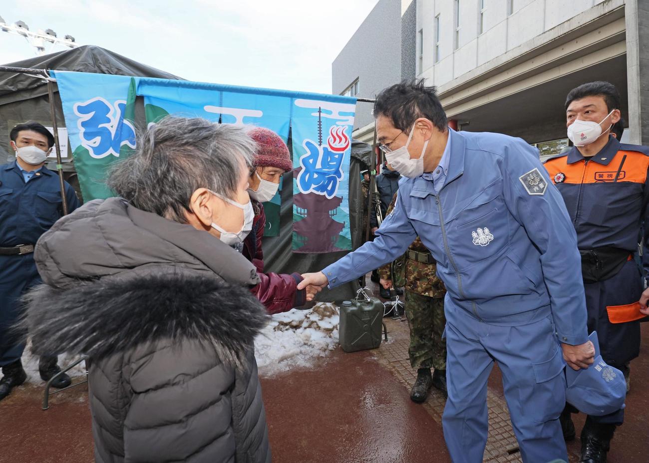 石川県輪島市の避難所を訪れ、被災者と握手する岸田首相＝14日午前（代表撮影）