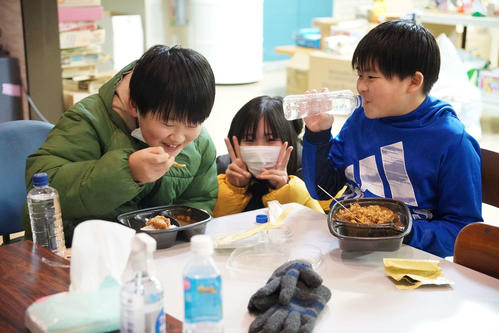 避難所で配られたカレーを食べる子どもたち（撮影・沢田直人）