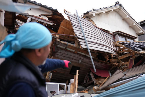 升井克宗さんと妻の佳美さんは震災当時、自宅の1階にいたという。懸命にこたつの中へもぐりわずかな隙間により奇跡的にも助かったと話してくれた。写真は震災時に逃げ出した場所を指さす升井克宗さん（撮影・横山健太）