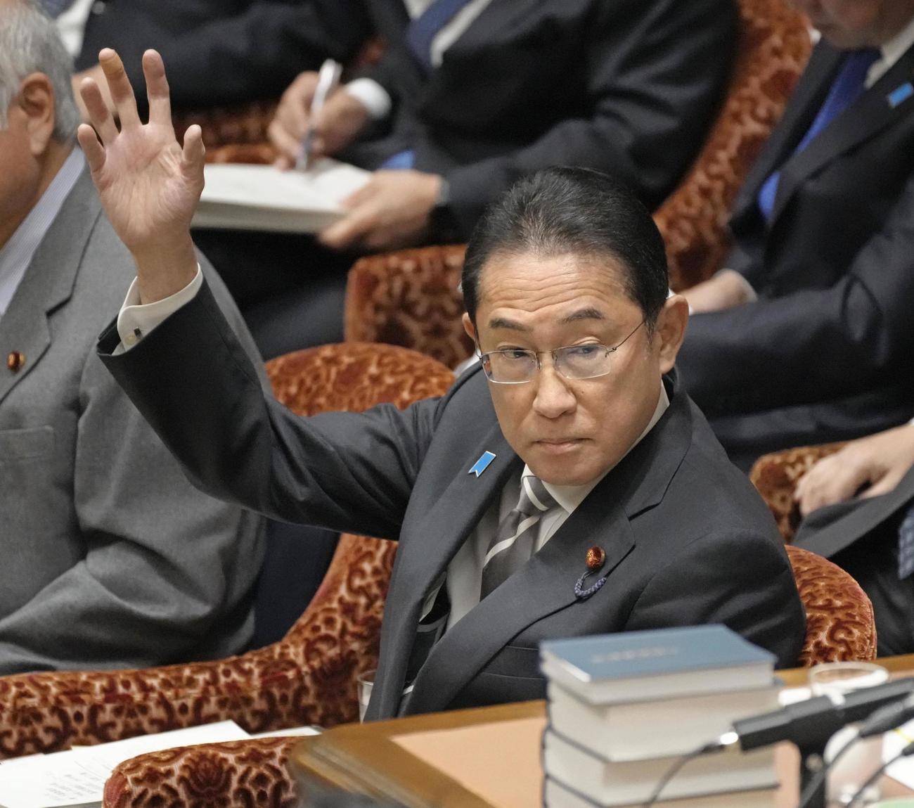 衆院予算委で答弁のため挙手する岸田首相（共同）