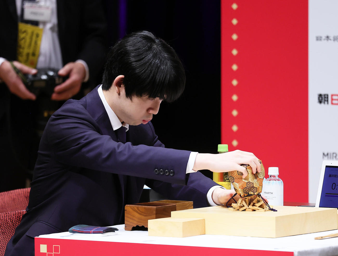 巾着から駒を取り出す藤井聡太八冠（撮影・足立雅史）