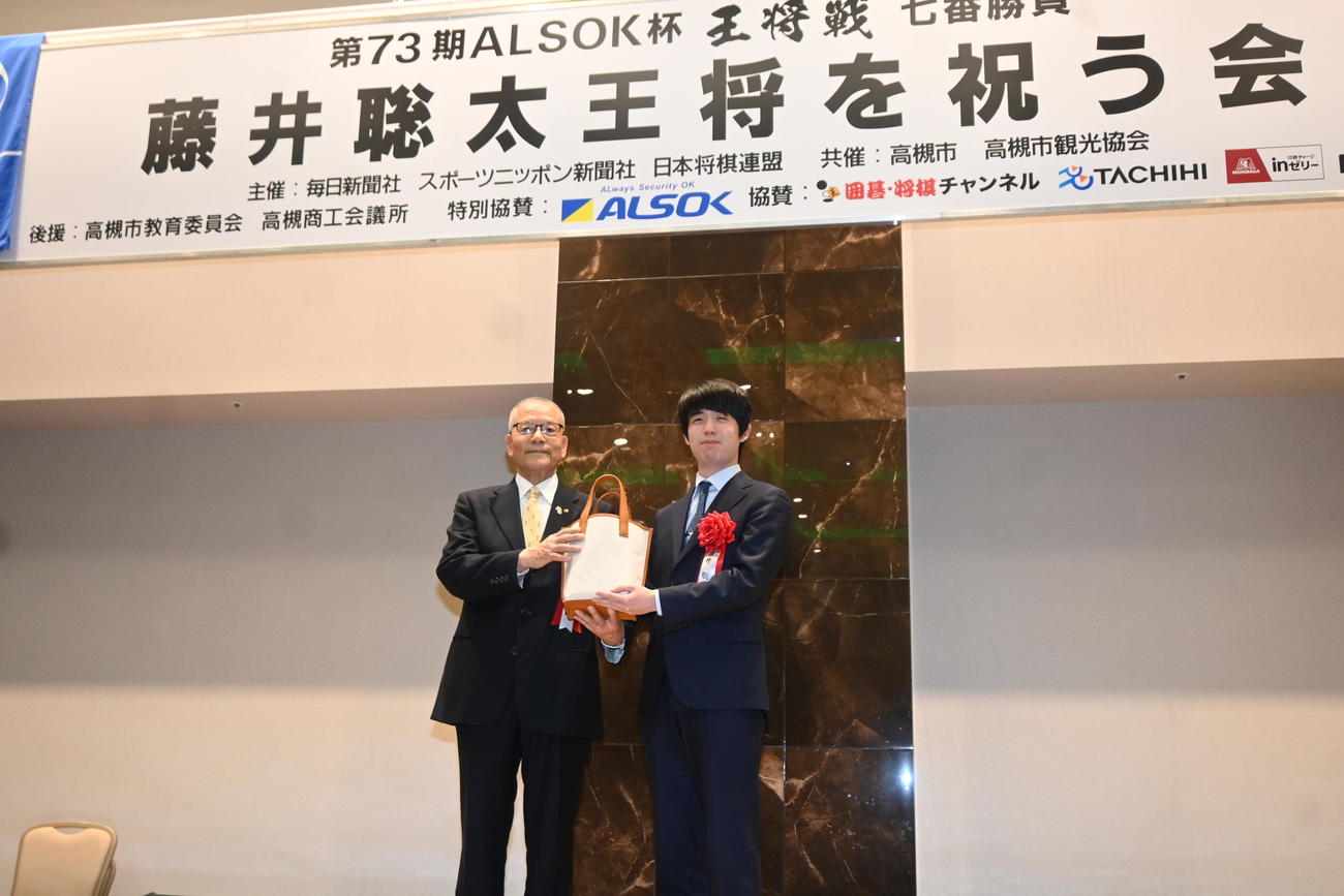 高槻市の特産品などの詰め合わせをプレゼントされた藤井聡太王将（撮影・松浦隆司）