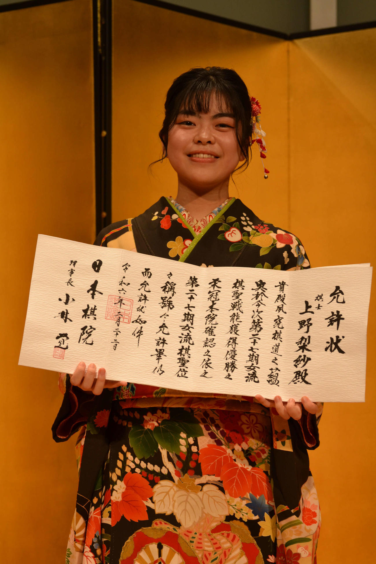 就位式で允許（いんきょ）状を手にする上野梨紗女流棋聖
