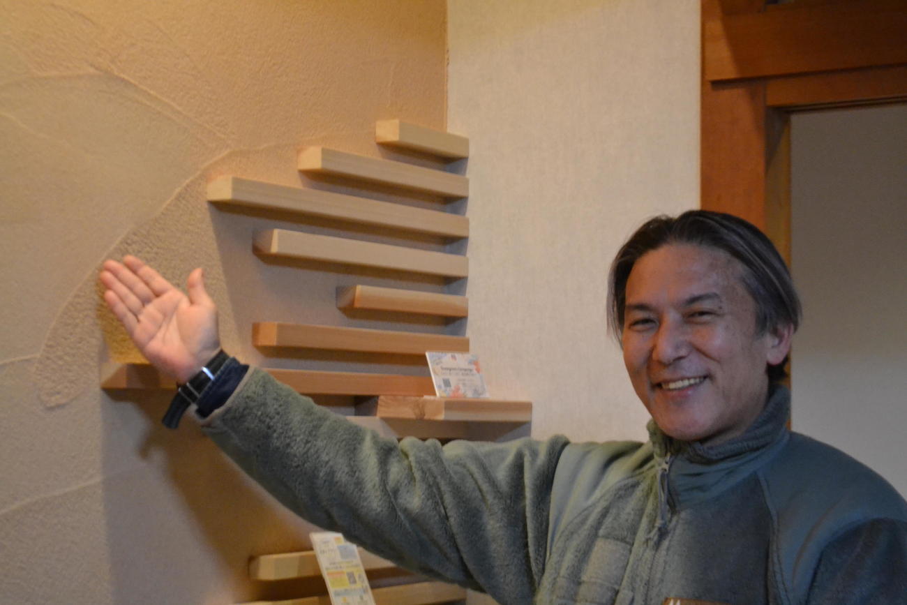 休暇村越前三国で不燃木材を使った木ぬり壁について説明する「セルフネン」の相原利治氏