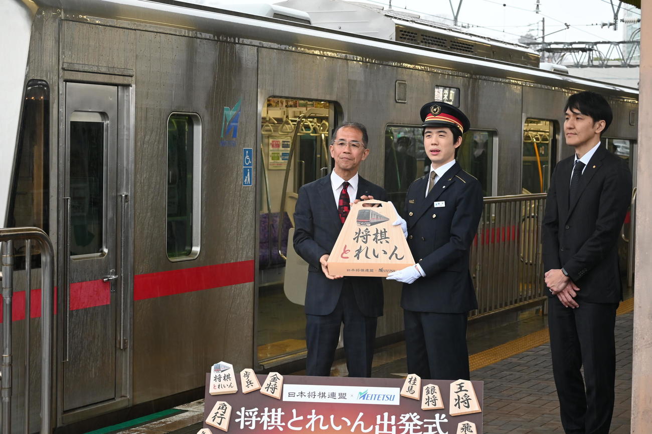 名古屋鉄道「尾張瀬戸駅」で、王将の駒のステッカーを貼った「将棋とれいん」の発車式に出席した藤井聡太8冠（中央）（撮影・松浦隆司）