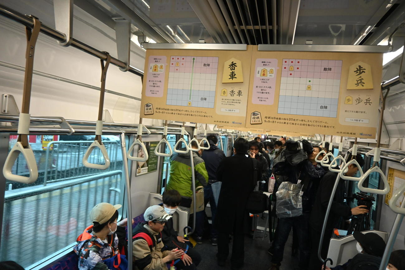 名古屋鉄道「尾張瀬戸駅」で、王将の駒のステッカーを貼った「将棋とれいん」の車内（中央）（撮影・松浦隆司）