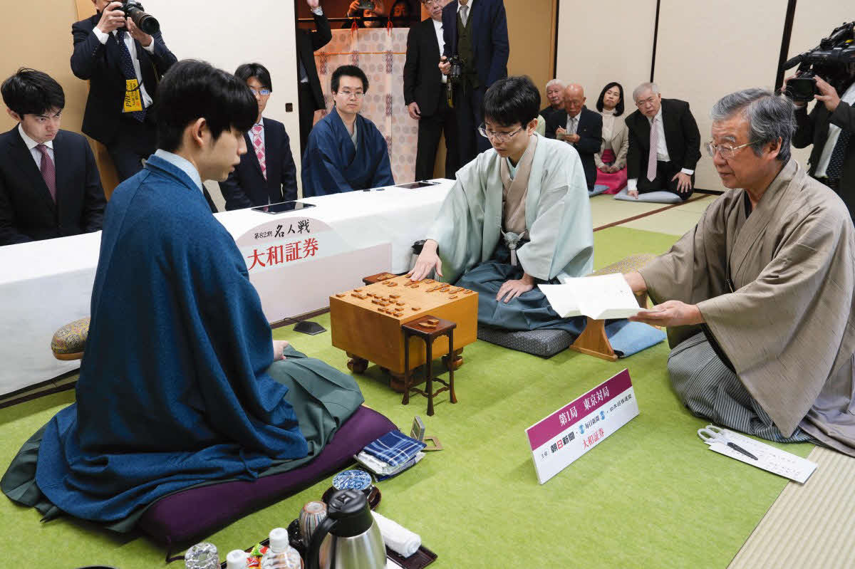 藤井聡太名人（左）は立会人の青野照市九段（右）が開封した豊島将之九段（中央）の封じ手を確認する（日本将棋連盟提供）