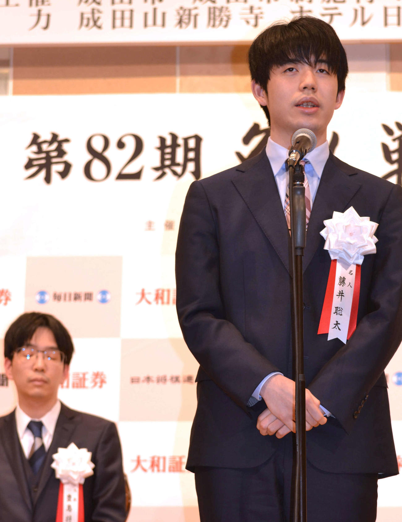 名人戦第2局前夜祭で決意表明する藤井聡太名人。左は豊島将之九段