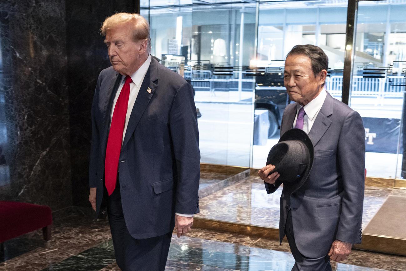 23日、ニューヨークのトランプタワーで自民党の麻生太郎副総裁（右）と一緒に歩くトランプ前米大統領（AP＝共同）