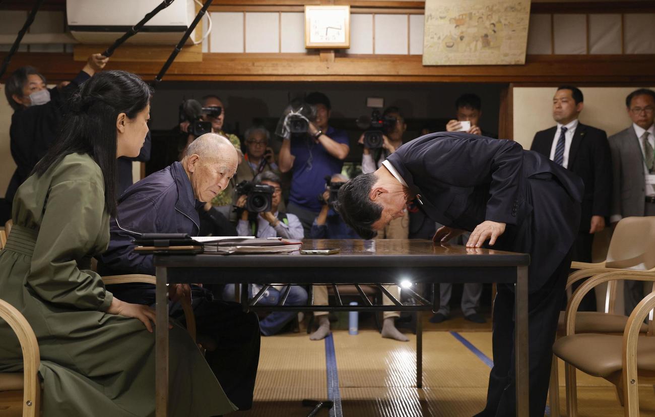 水俣病患者連合の松崎重光副会長（左から2人目）らに謝罪する伊藤環境相＝8日午後、熊本県水俣市（共同）