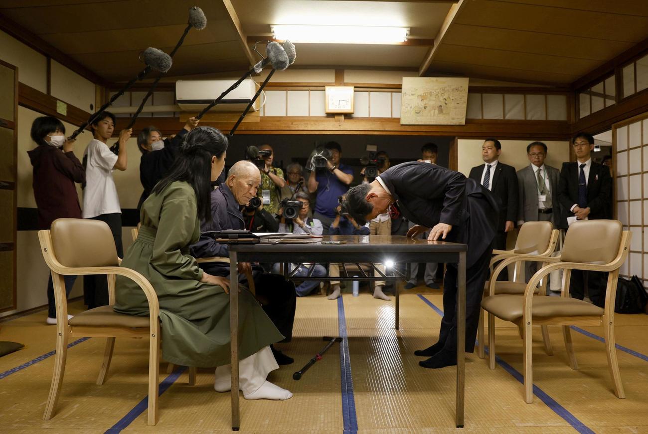 水俣病患者連合の松崎重光副会長（左から2人目）らに謝罪する伊藤環境相＝8日午後、熊本県水俣市（共同）