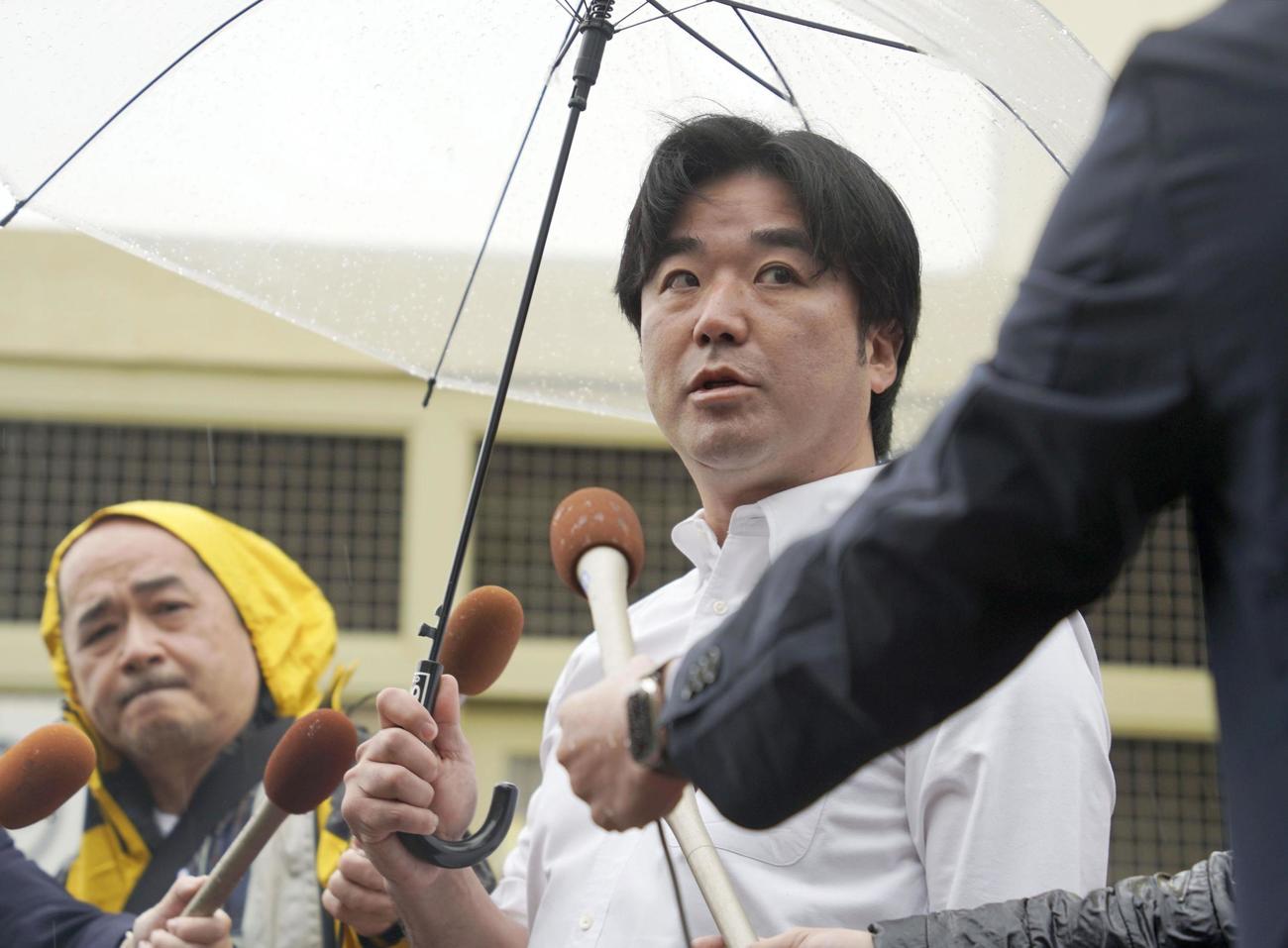家宅捜索を受け、朝霞市内で報道陣の取材に応じるつばさの党の黒川敦彦代表（右）（共同）