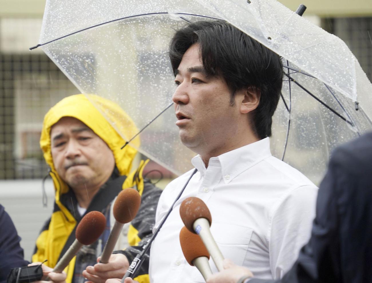 家宅捜索を受け、朝霞市内で報道陣の取材に応じるつばさの党の黒川敦彦代表（右）（共同）