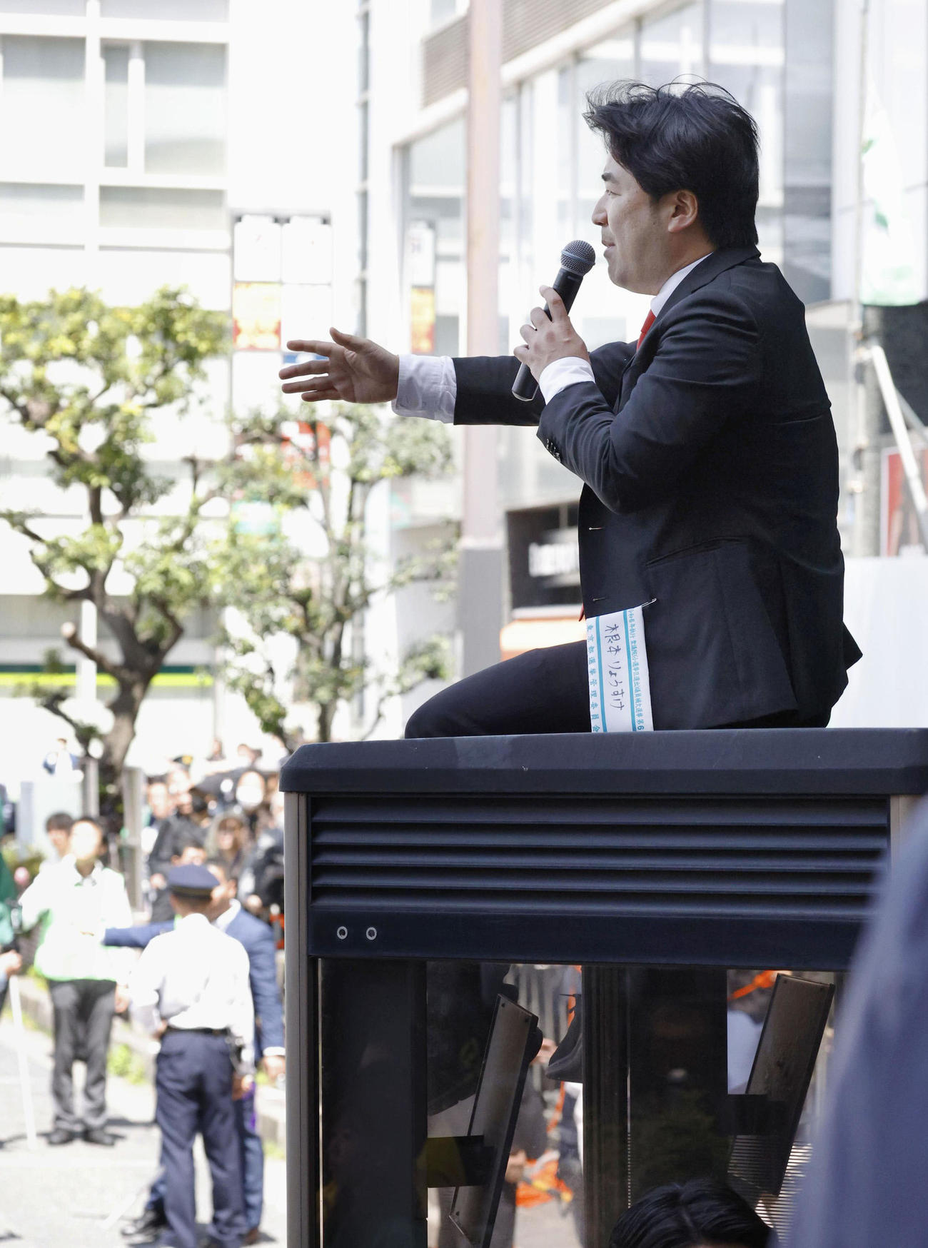 4月、衆院東京15区補欠選挙の告示日、立候補した乙武洋匡氏の演説会場で、電話ボックスの上から声を上げる政治団体「つばさの党」の黒川敦彦代表（共同）