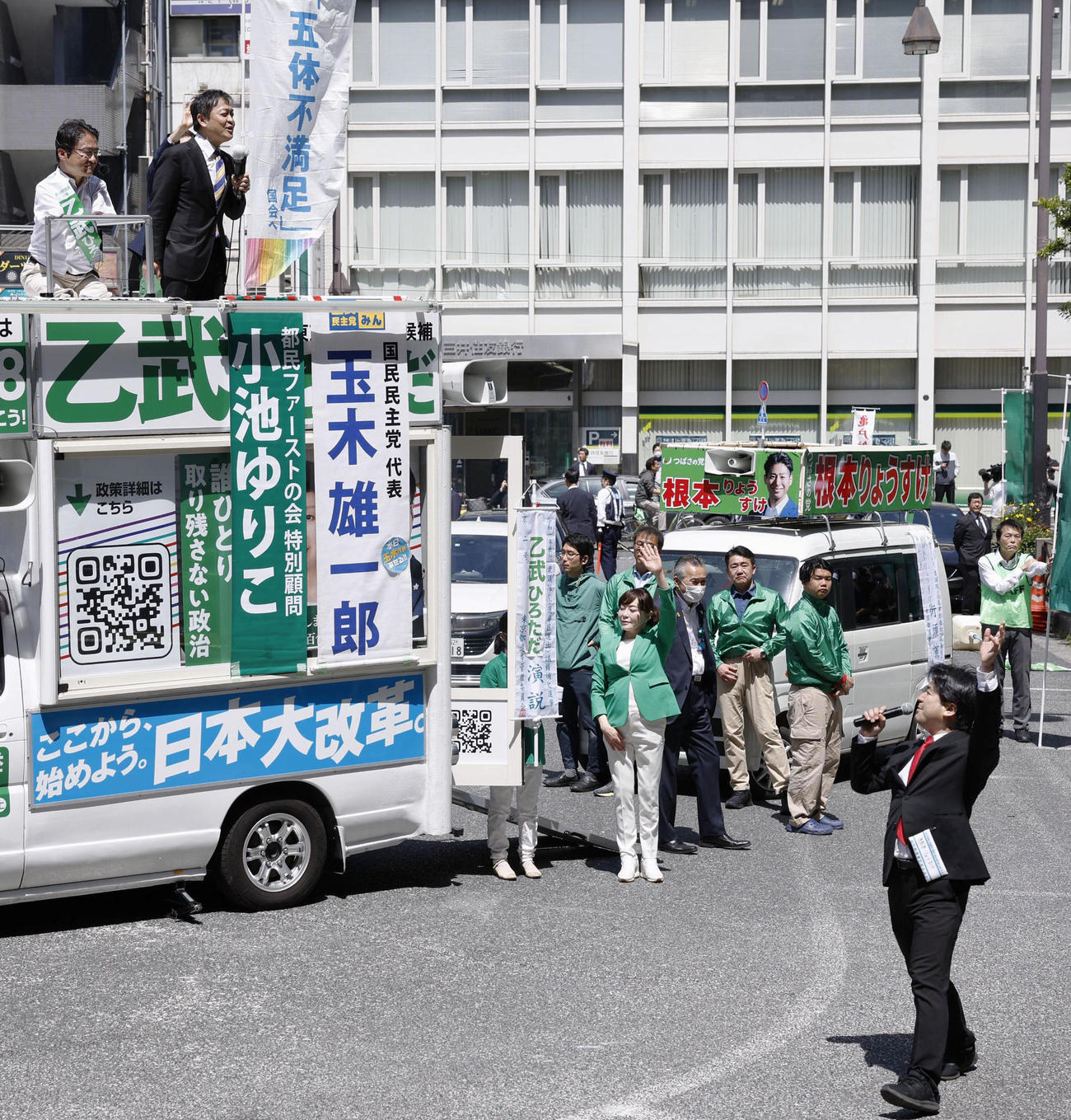 4月、衆院東京15区補欠選挙の告示日、立候補した乙武洋匡氏（左上）の演説会場周辺で声を上げる政治団体「つばさの党」の黒川敦彦代表（右下）（共同）