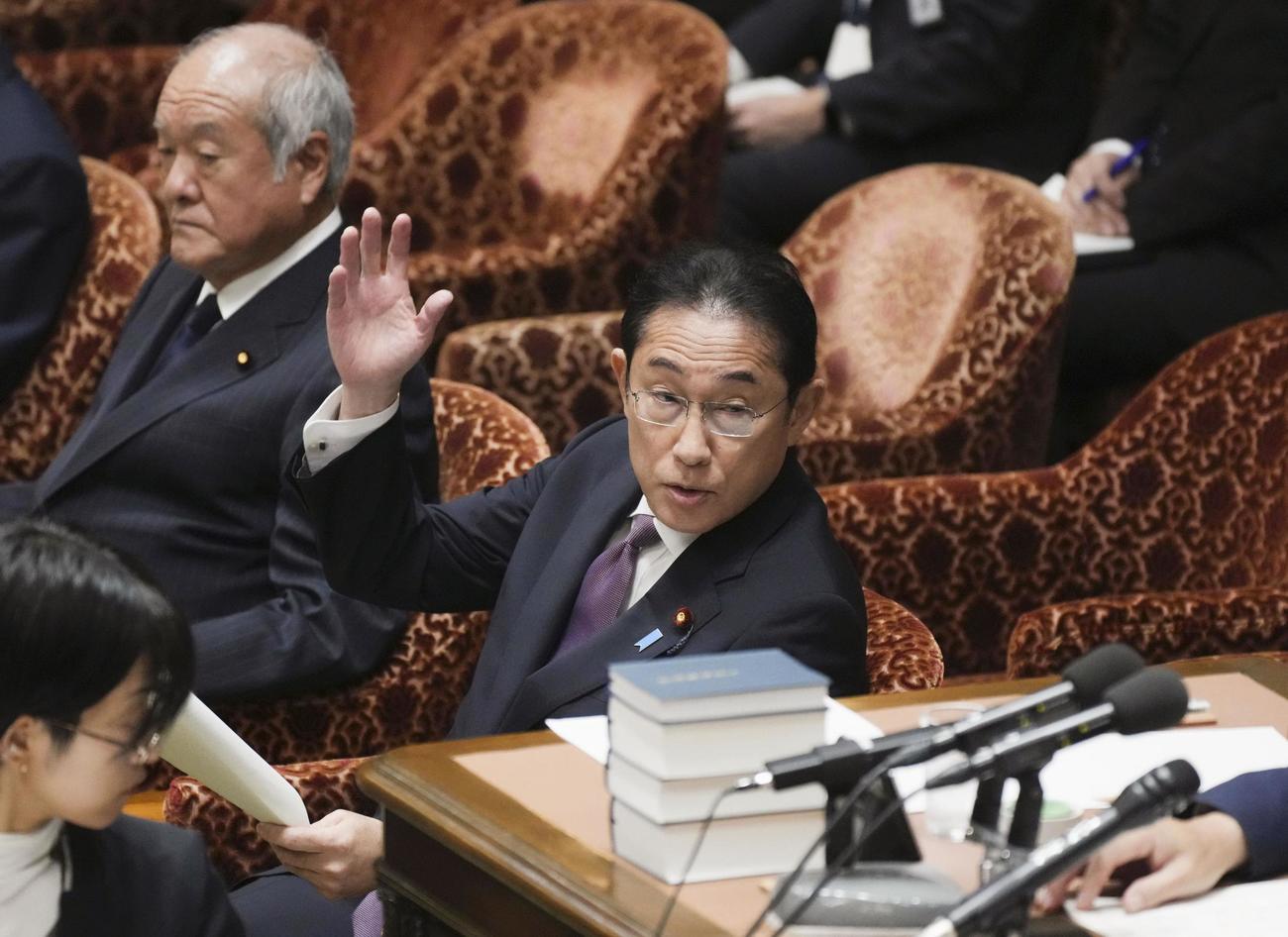 衆院予算委の集中審議で、答弁のため挙手する岸田首相（共同）