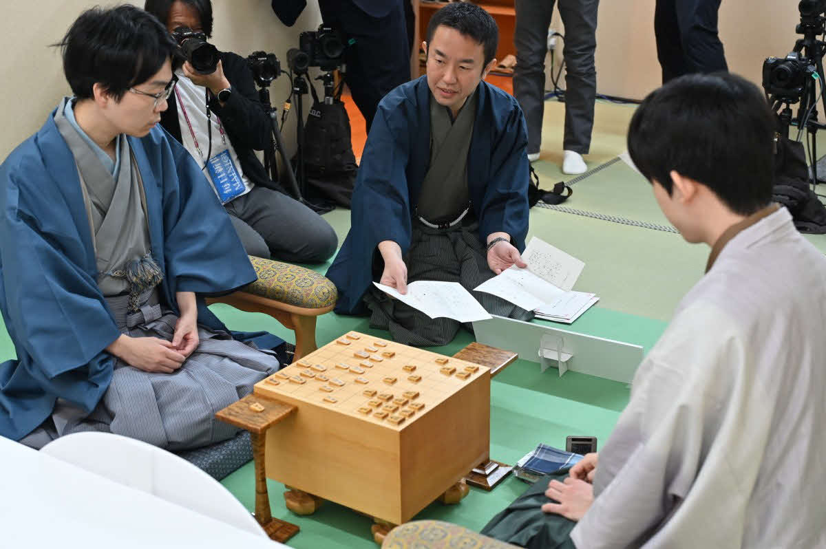 豊島将之九段（左）に藤井聡太名人（右）の封じ手を見せる立会人の屋敷伸之九段（日本将棋連盟提供）