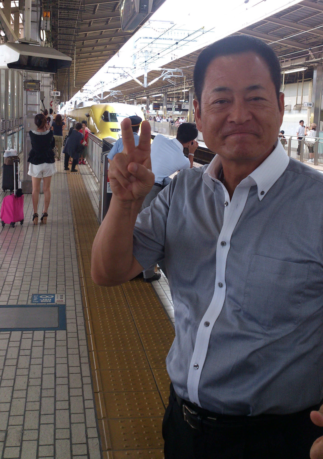 新横浜駅のホームで「ドクターイエロー」（後方）をバックにピースサインを決めるDeNA中畑清監督＝2013年8月26日