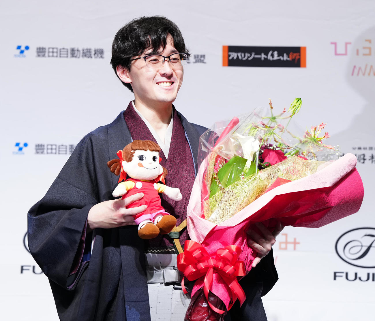 初タイトルを獲得しペコちゃん人形を手に笑顔を見せる伊藤匠新叡王（撮影・江口和貴）