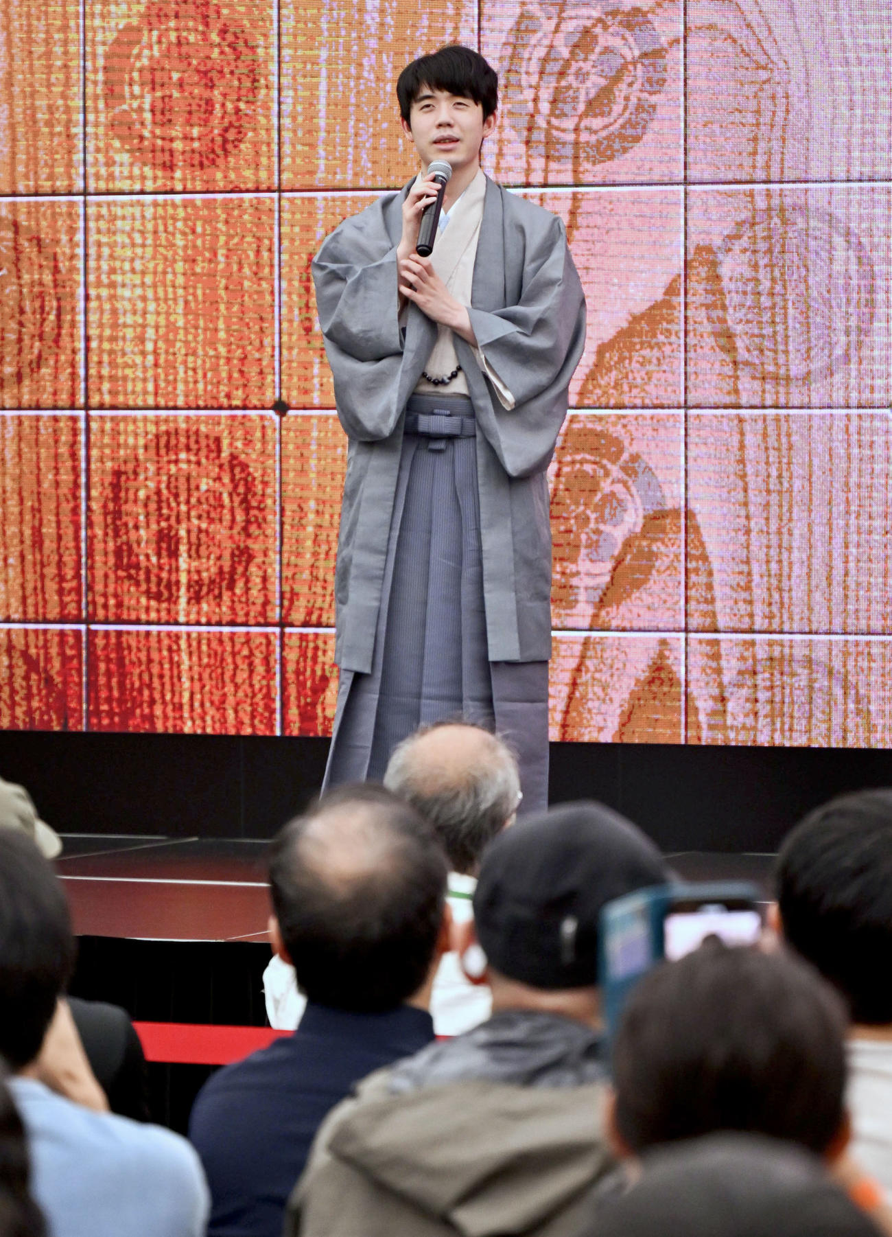 将棋の第95期棋聖戦5番勝負を制して5連覇を達成し、大盤解説会場で喜びを語る藤井聡太棋聖。史上最年少で自身初の「永世称号」の資格を得た＝1日午後、名古屋市（共同）