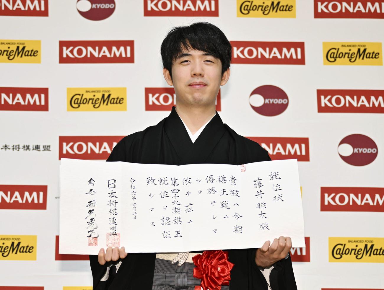 就位状を手にする藤井聡太棋王（共同）