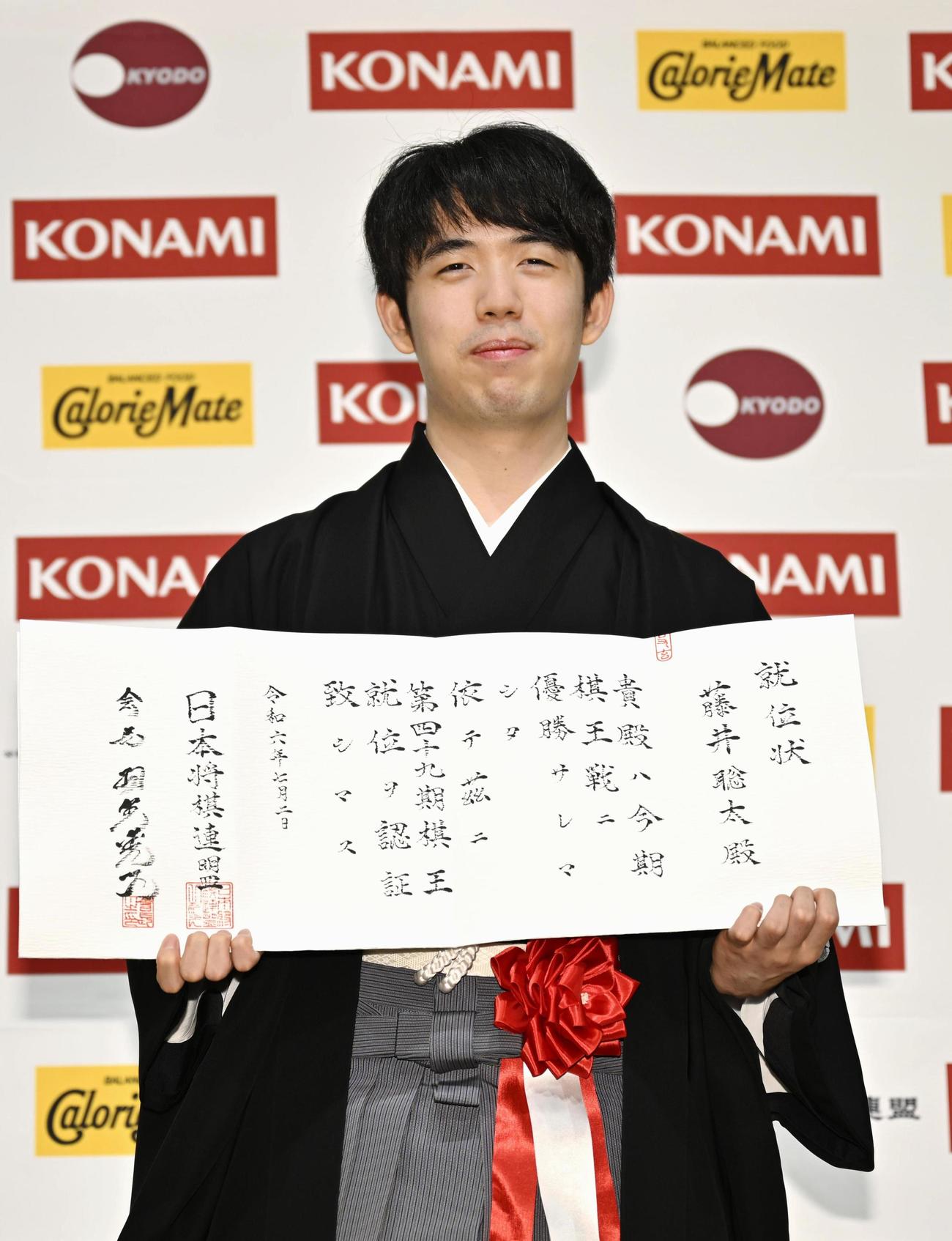 就位状を手にする藤井聡太棋王（共同）