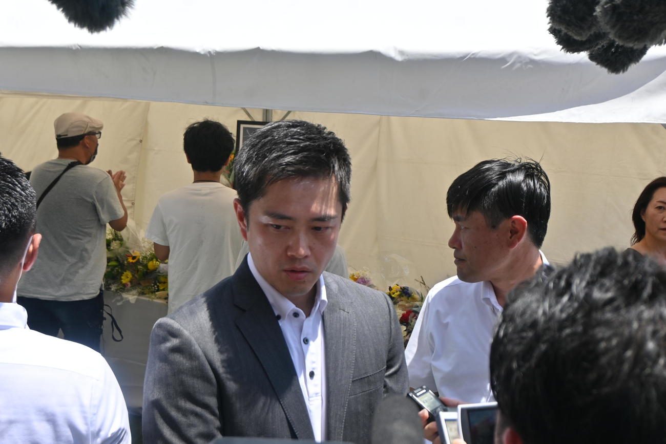 現場となった奈良・大和西大寺駅前に設置された献花台を訪れ、黙とうをささげた吉村洋文知事（同5人目）（撮影・松浦隆司）