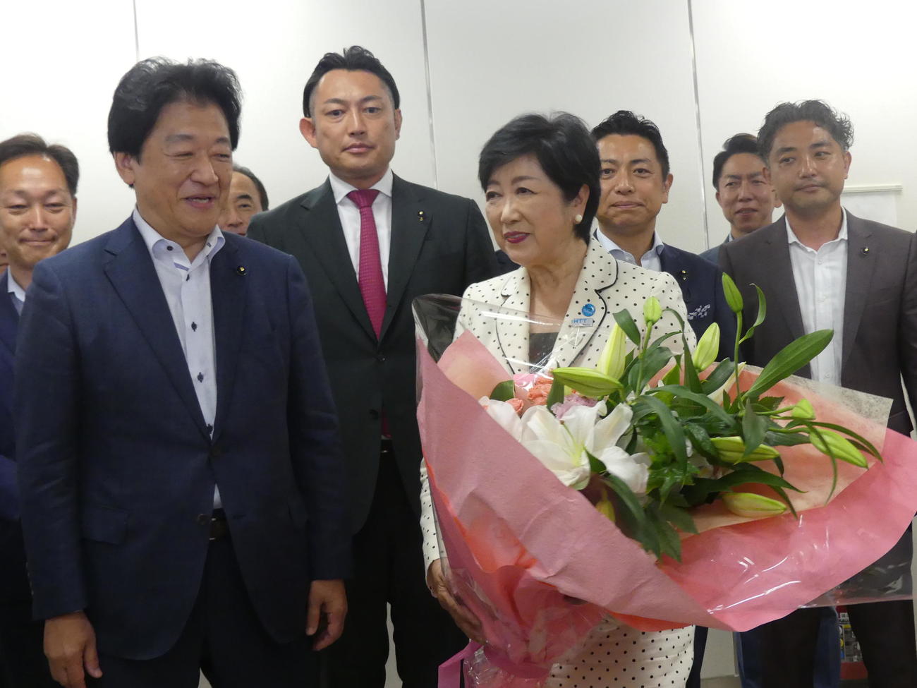 都知事選で支援を受けた都議会自民党へのあいさつ回りで、ユリの花をあしあらった花束を受け取る小池百合子都知事（撮影・中山知子）