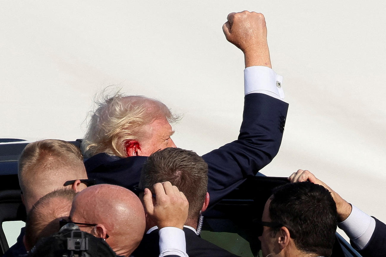 警備員に助けられながら拳を突き上げる共和党大統領候補のドナルド・トランプ前大統領。右耳付近からの出血も見られた（ロイター）