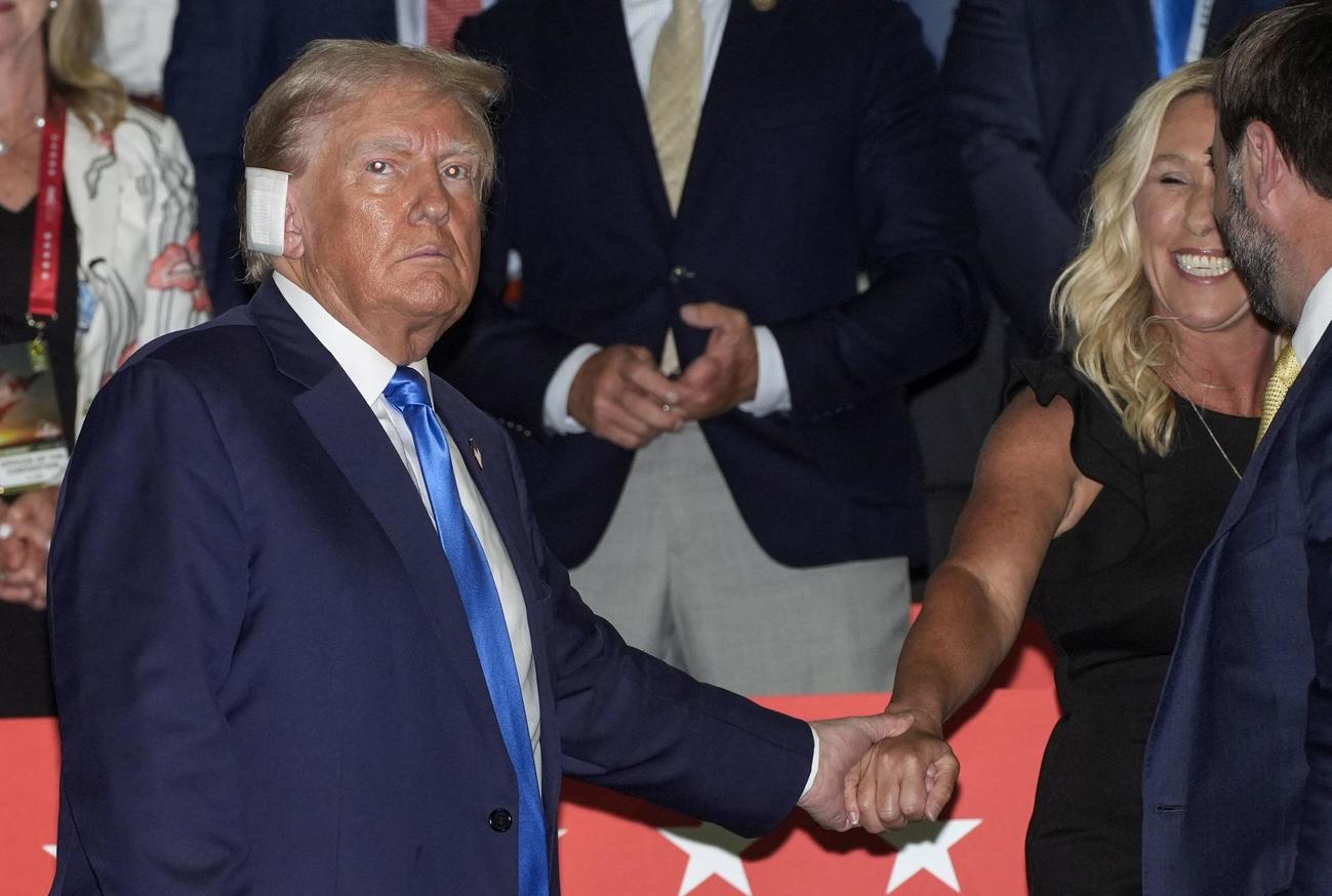 マージョリー・テイラー・グリーン下院議員と手をつなぐ共和党大統領候補のトランプ前大統領（ロイター）