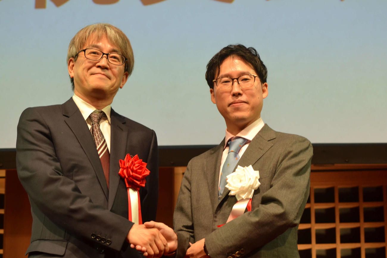 日本棋院創立100周年祝賀会に来賓として訪れた日本将棋連盟会長の羽生善治九段（左）と悪手を交わす井山裕太3冠