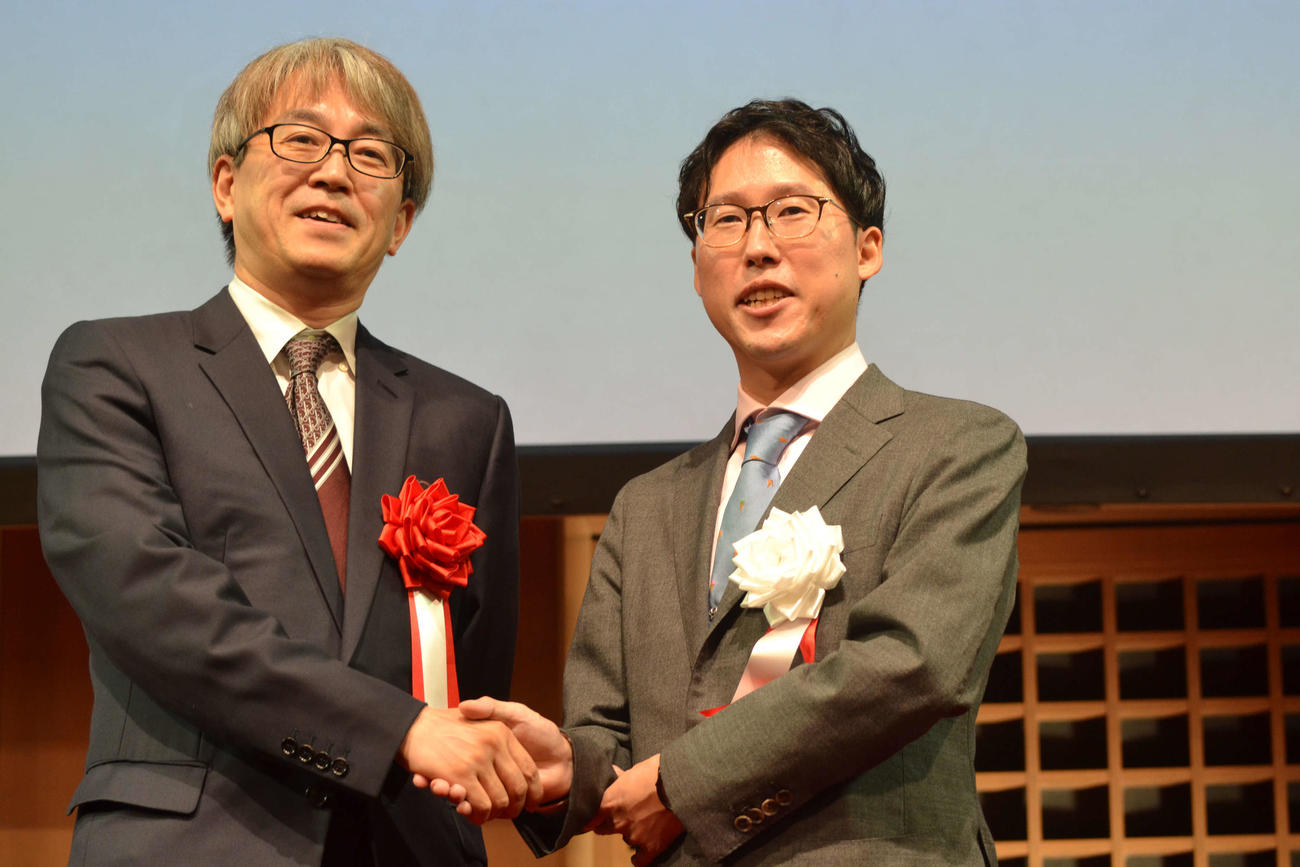 日本棋院創立100周年祝賀会に来賓として訪れた日本将棋連盟会長の羽生善治九段（左）と悪手を交わす井山裕太3冠