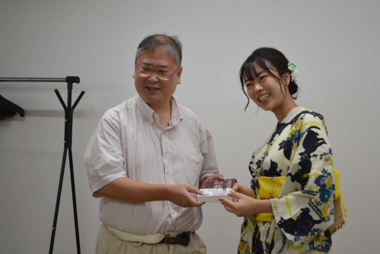 上野愛咲美新人王（右）はサイン入り本をファンにプレゼントにして撮影に応じる