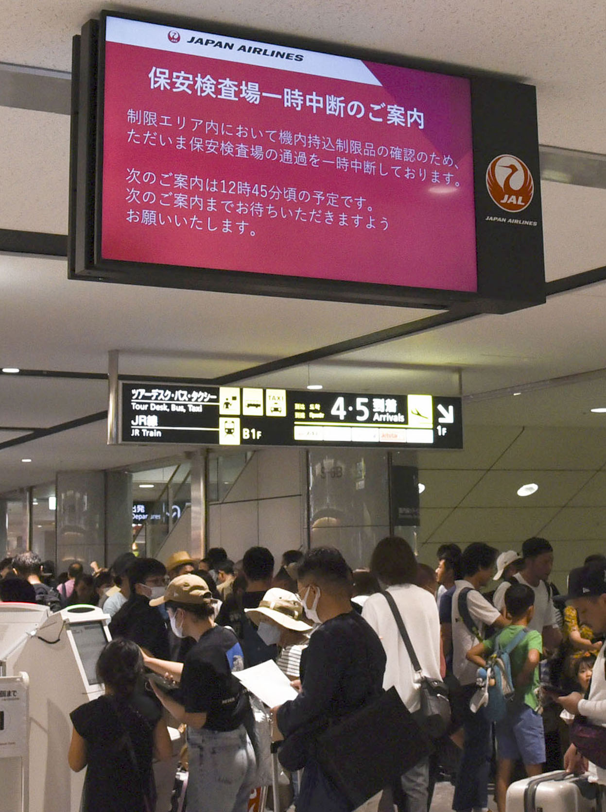 新千歳空港で保安検査中断の案内を表示するモニター（共同）