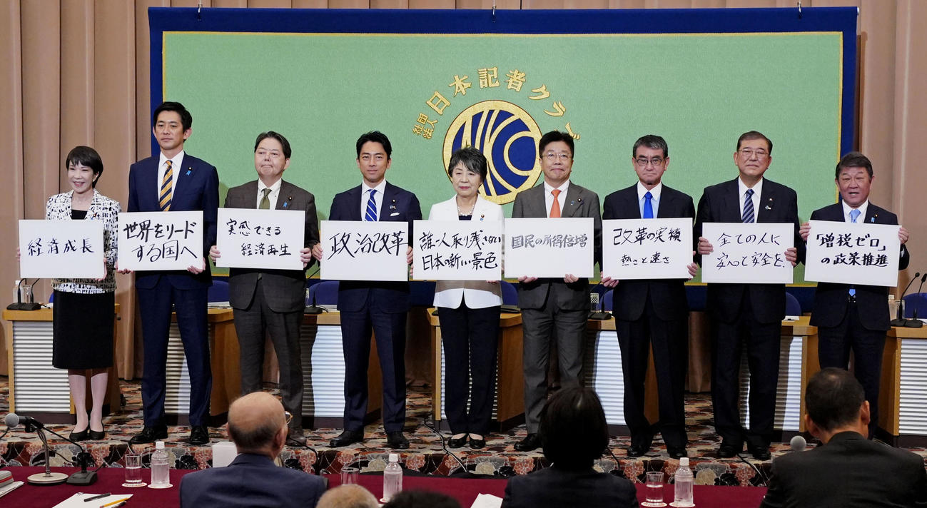 自民党総裁選の立候補者討論会で、ボードを手に記念写真に納まる（左から）高市経済安保相、小林前経済安保相、林官房長官、小泉元環境相、上川外相、加藤元官房長官、河野デジタル相、石破元幹事長、茂木幹事長（共同）
