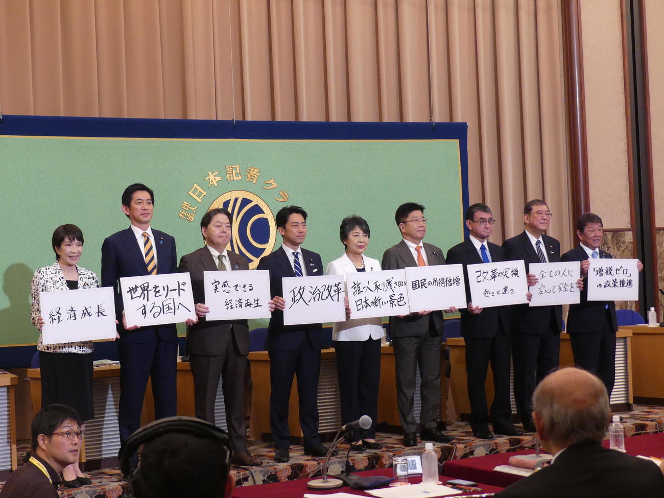 日本記者クラブの自民党総裁選候補者討論会を前に、キャッチフレーズを掲げて写真撮影に応じる9人の候補者（2024年9月14日撮影）