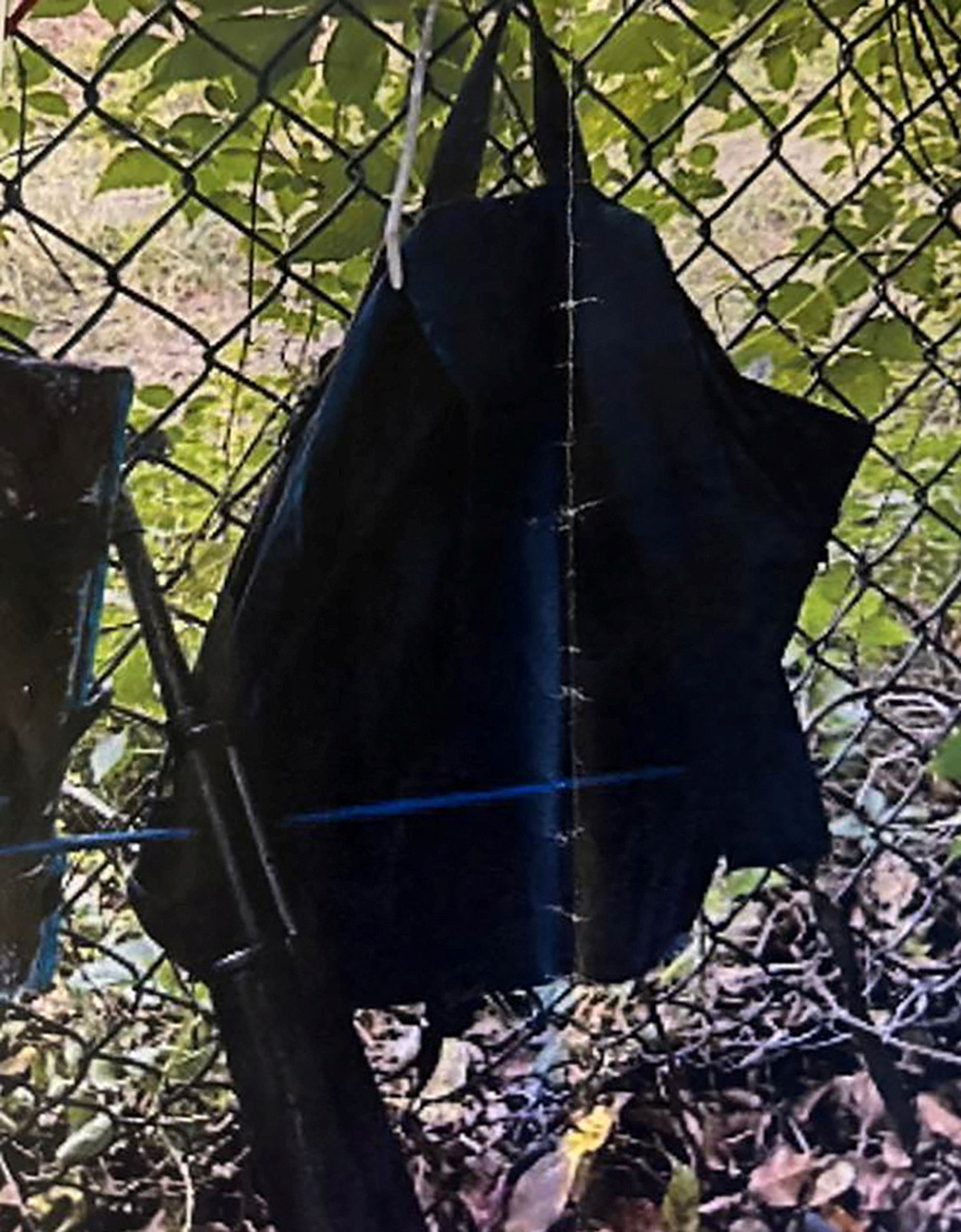 トランプ前大統領がプレーしていたゴルフ場のフェンスにかけられたリュックサックと自動小銃の写真。暗殺未遂事件後の撮影で記者会見時に提示された（ロイター）