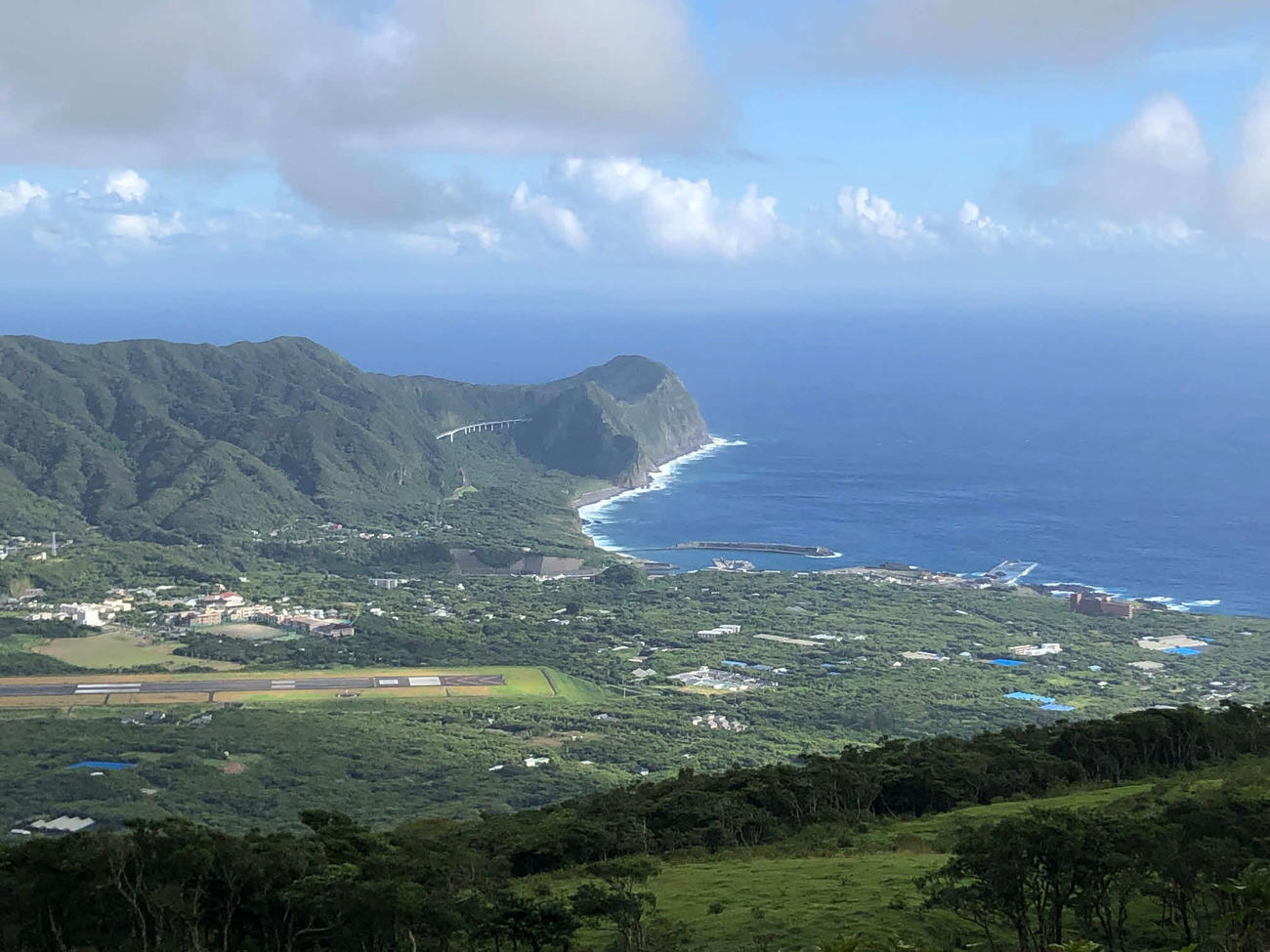 八丈島の八丈島空港の滑走路（左）と八重根港（右）（2024年8月28日）