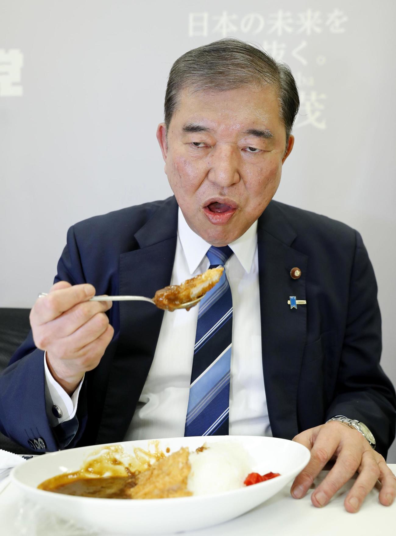 自民党総裁選の投開票を前に、決起集会でカツカレーを口にする石破茂氏（共同）