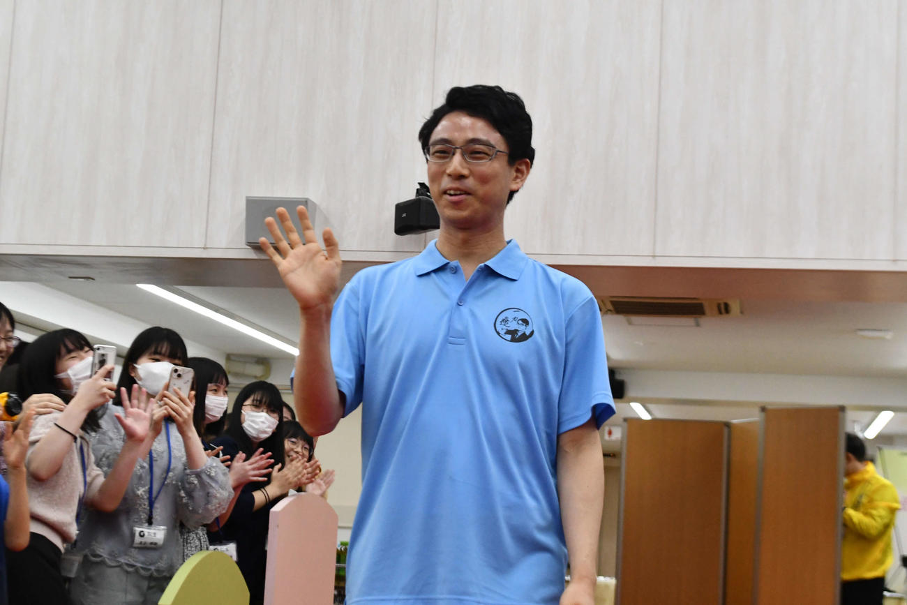 一力遼棋聖は祝福に訪れたファンに手を振りながら笑顔で入場する