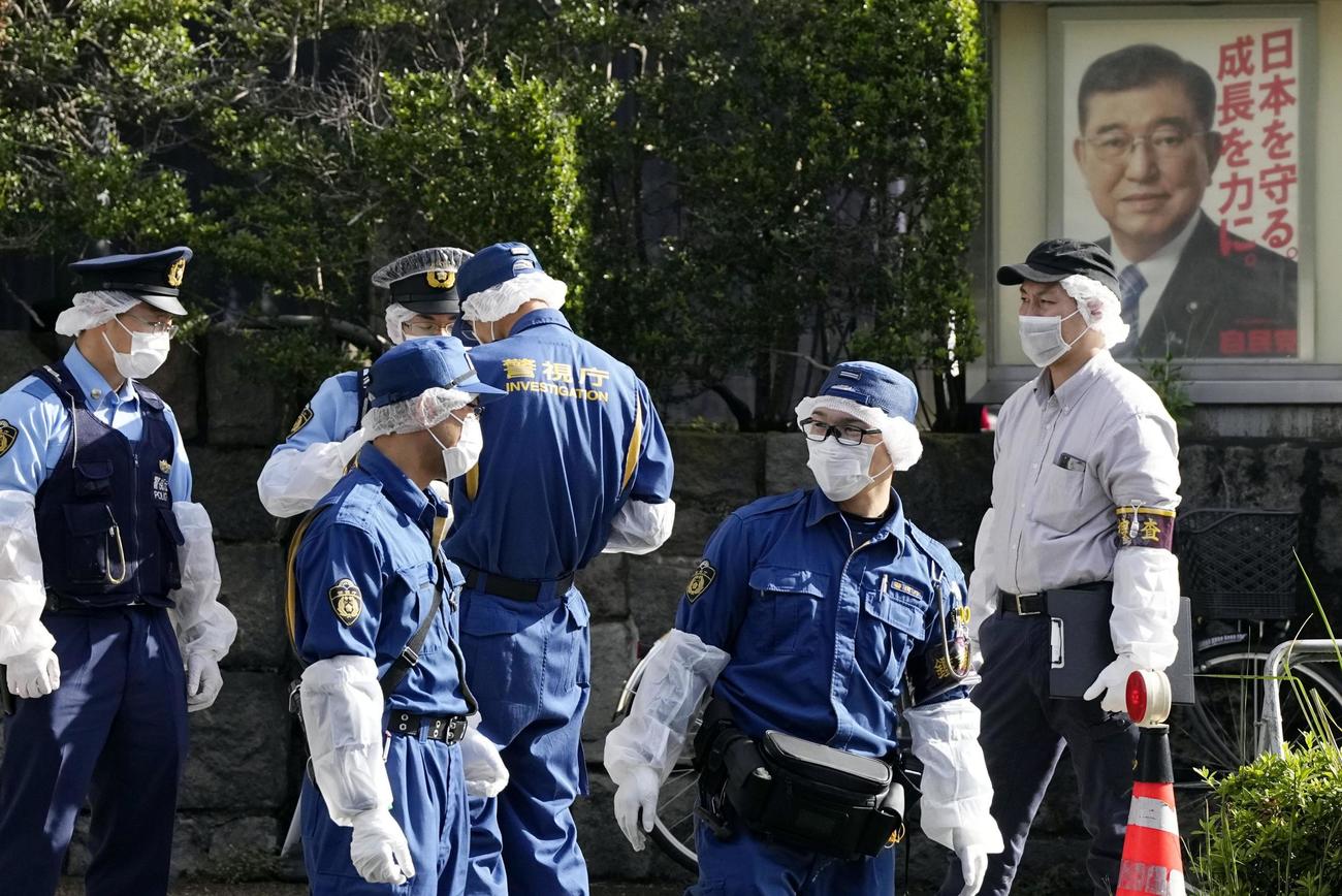 火炎瓶のようなものが投げ込まれた自民党本部付近に集まった警察官＝19日午前8時40分、東京・永田町（共同）