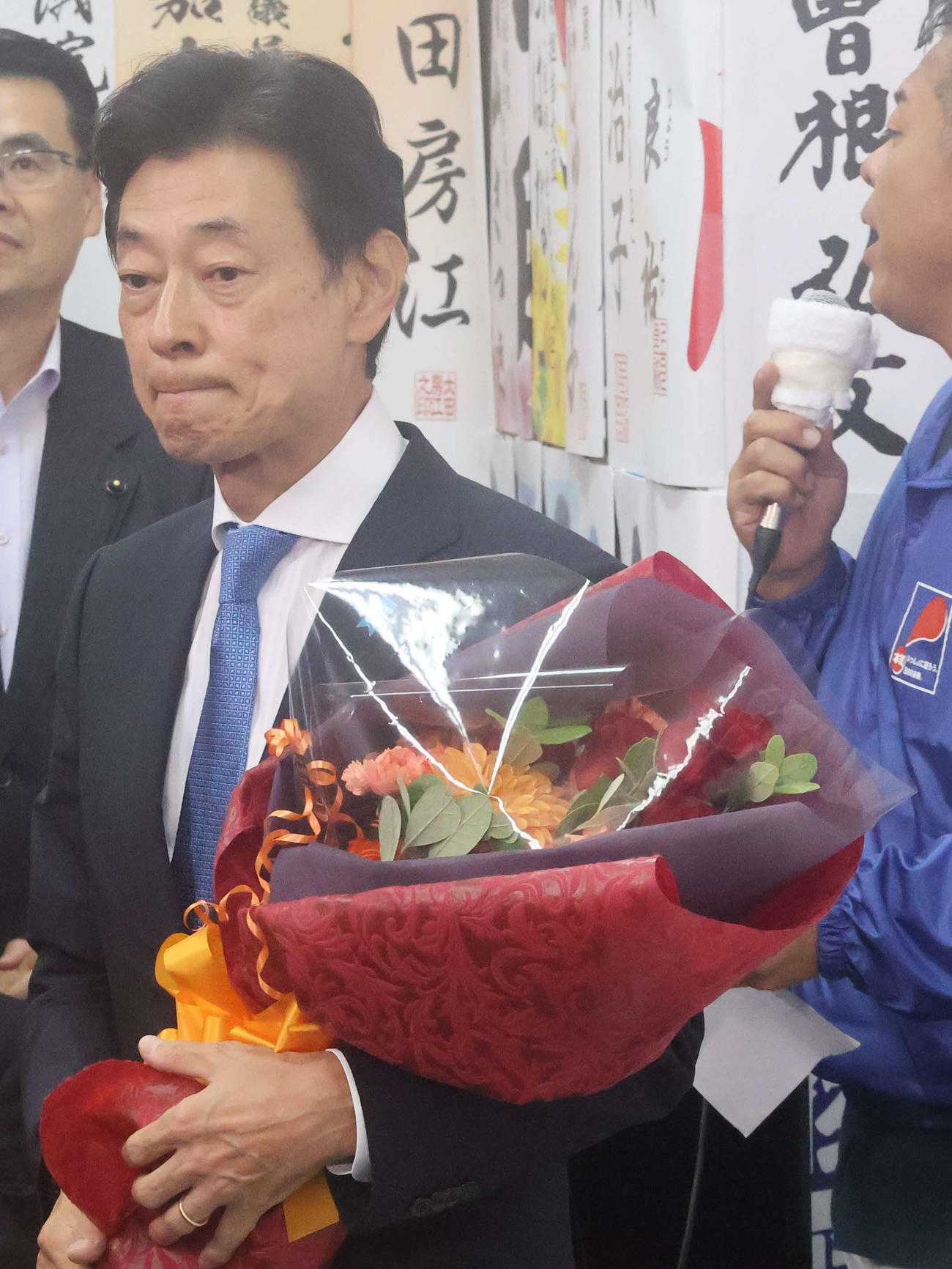 花束を持つ西村康稔氏（撮影・塚本光）