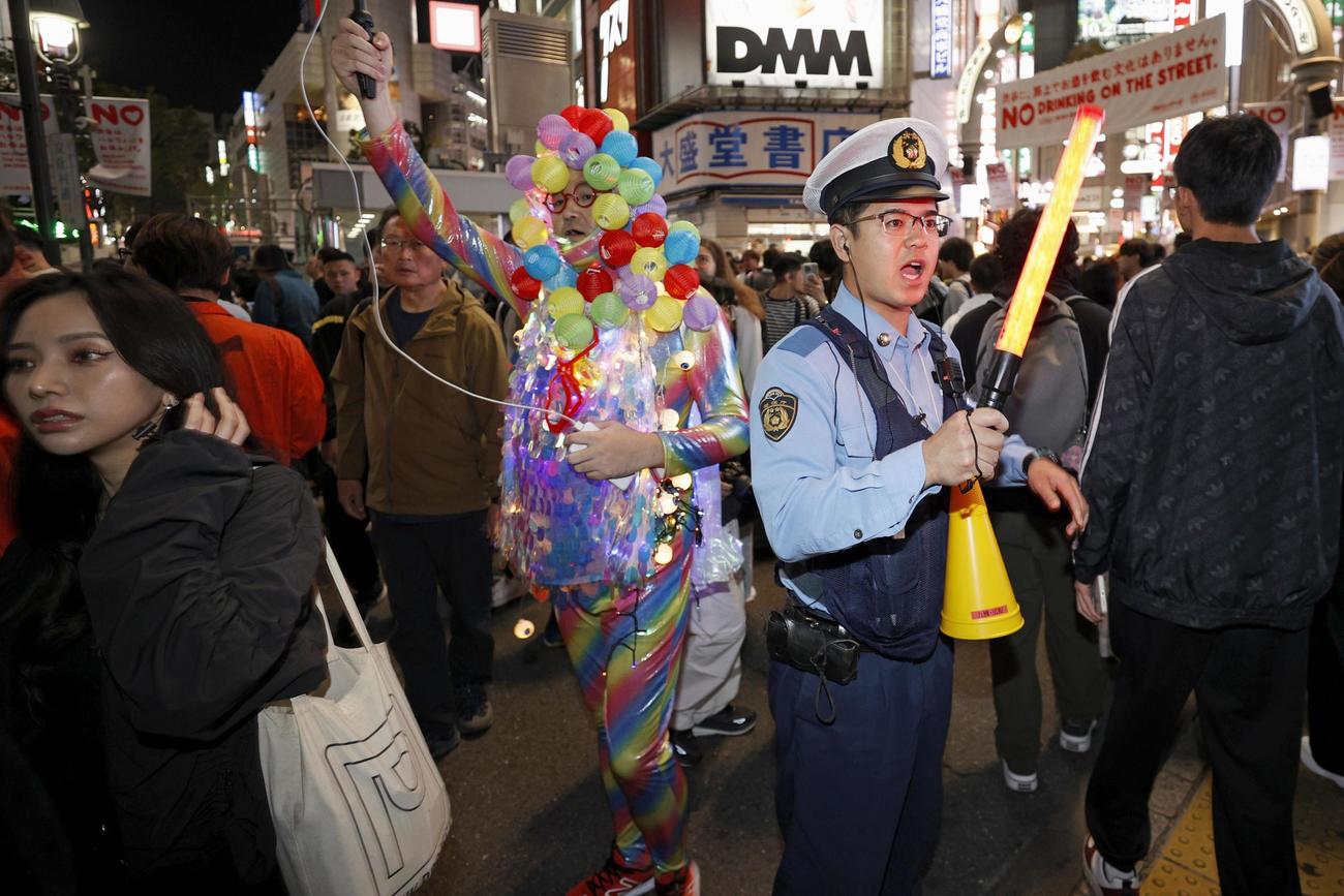 ハロウィーン当日を迎え、東京・渋谷のセンター街付近で歩行者を誘導する警察官（共同）