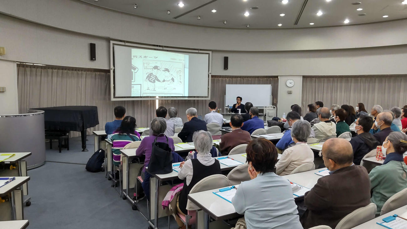 世田谷区立中央図書館で日刊スポーツに掲載された漫画を題材に講演するやくみつるさん