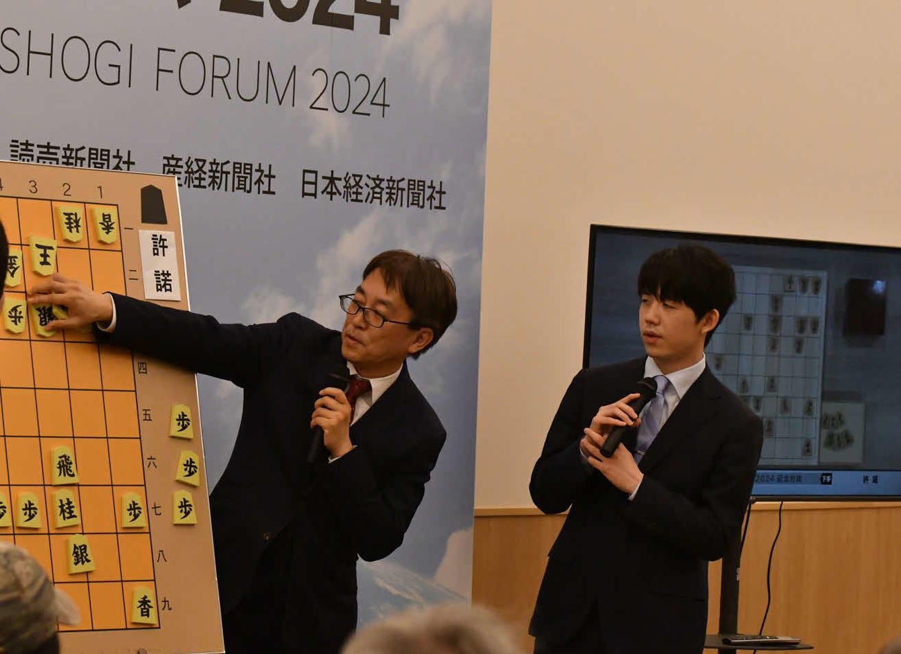 記念対局終了後に大盤解説会場で羽生善治九段（左）とともに指し手を振り返る藤井聡太7冠（右）