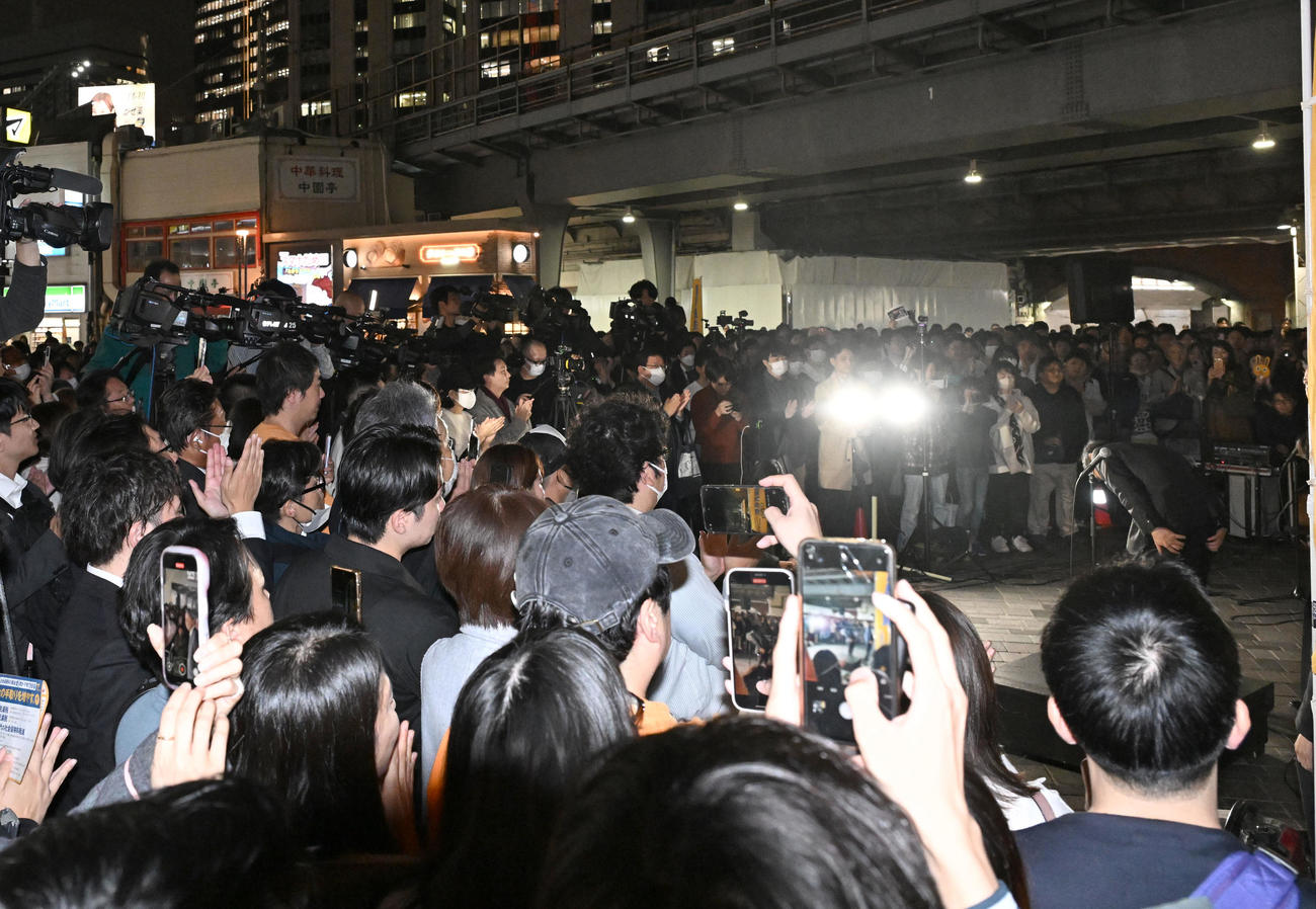 街頭演説に集まった多くの聴衆に向かって不倫スキャンダルについて深々と頭を下げる国民民主党の玉木代表（右中央）＝2024年11月11日